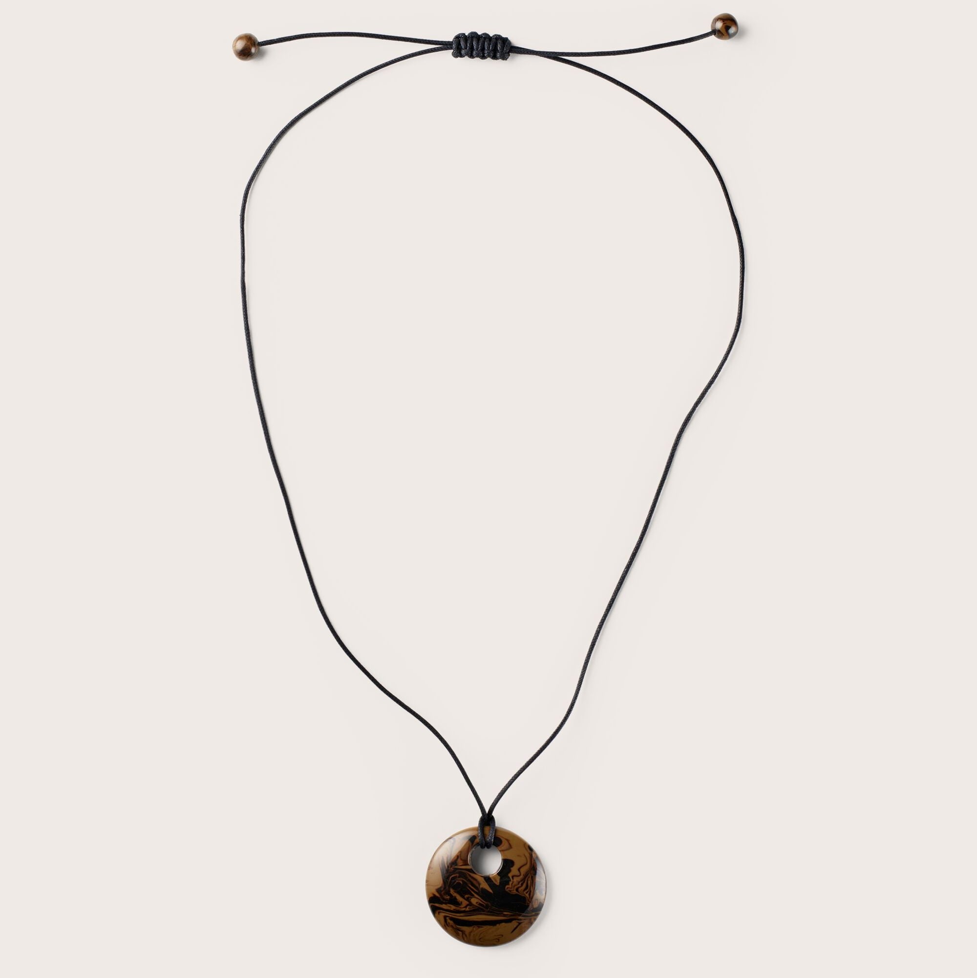 Necklace with a round brown pendant on a white background