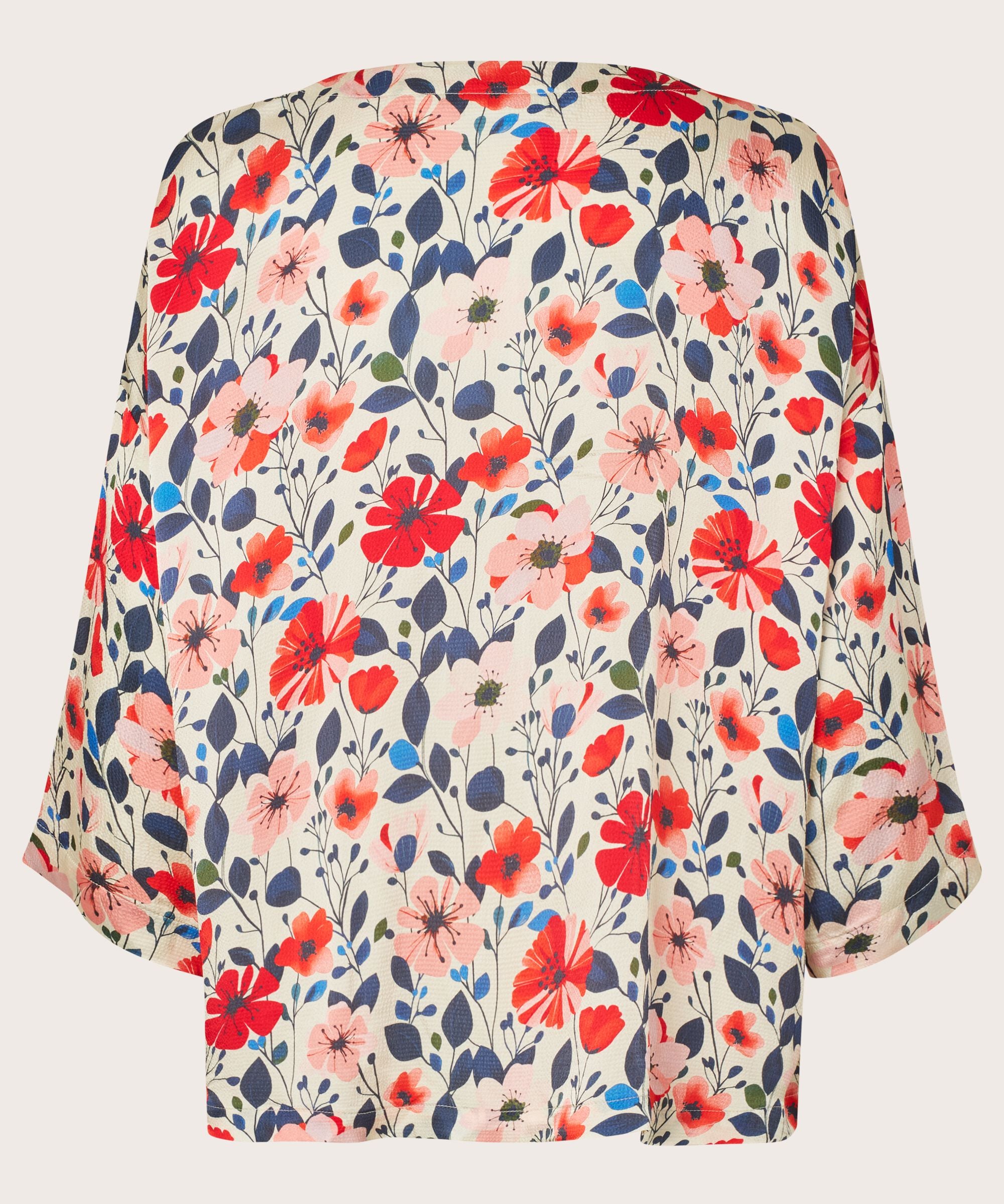 Floral patterned blouse with red, pink, and blue flowers on a beige background