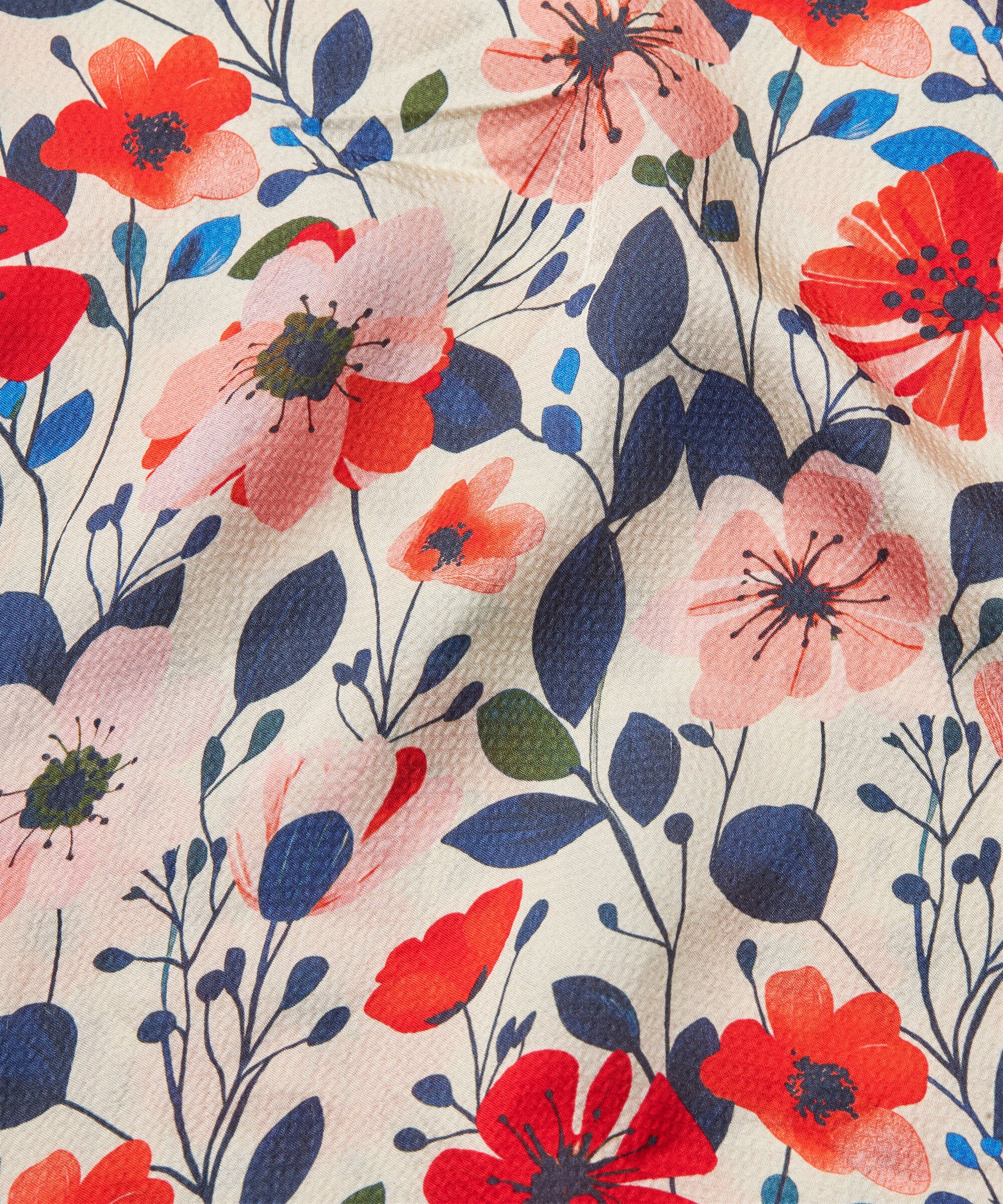 Floral pattern with red, pink, and blue flowers on a beige background