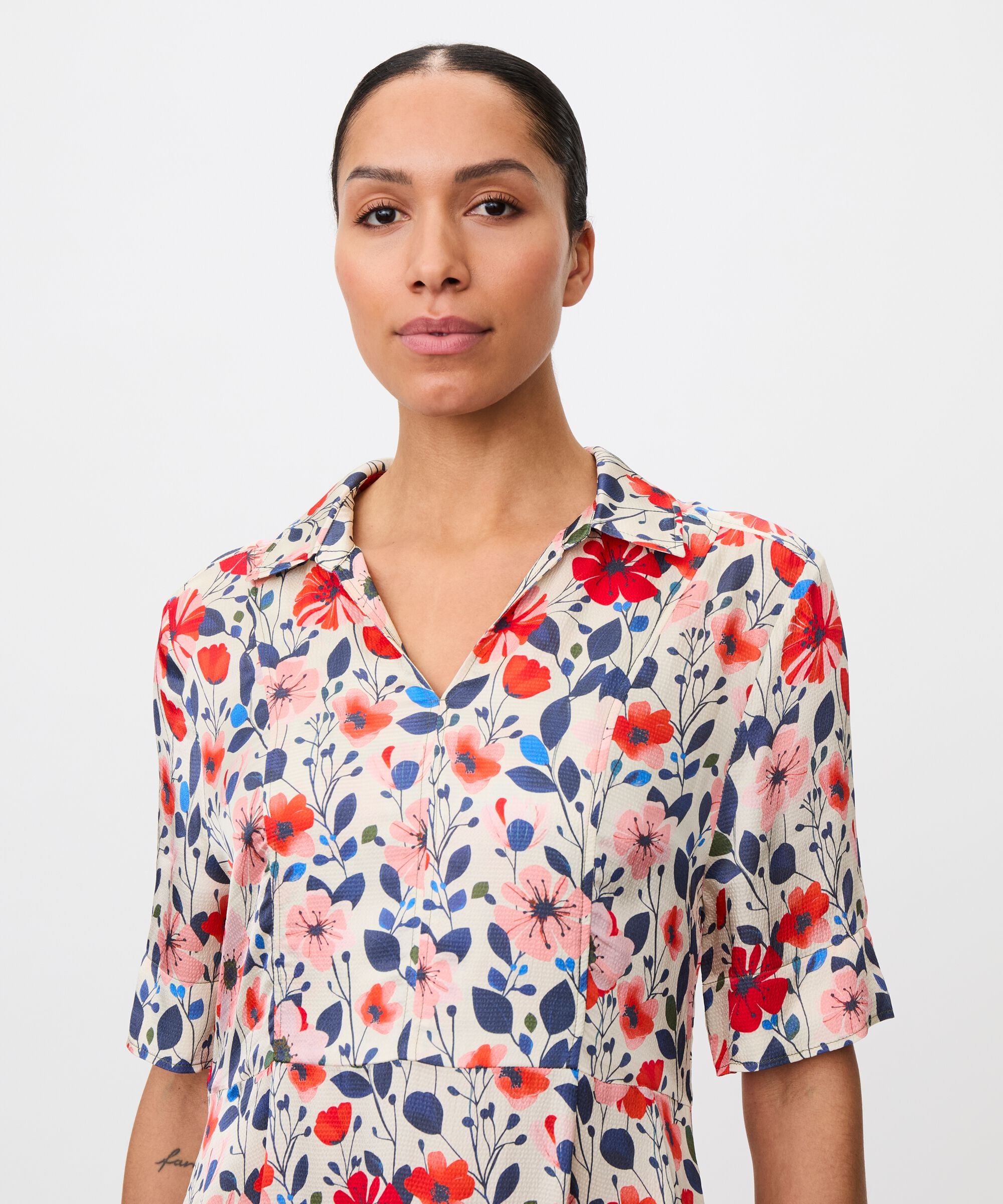 Woman wearing a floral dress with a plain background