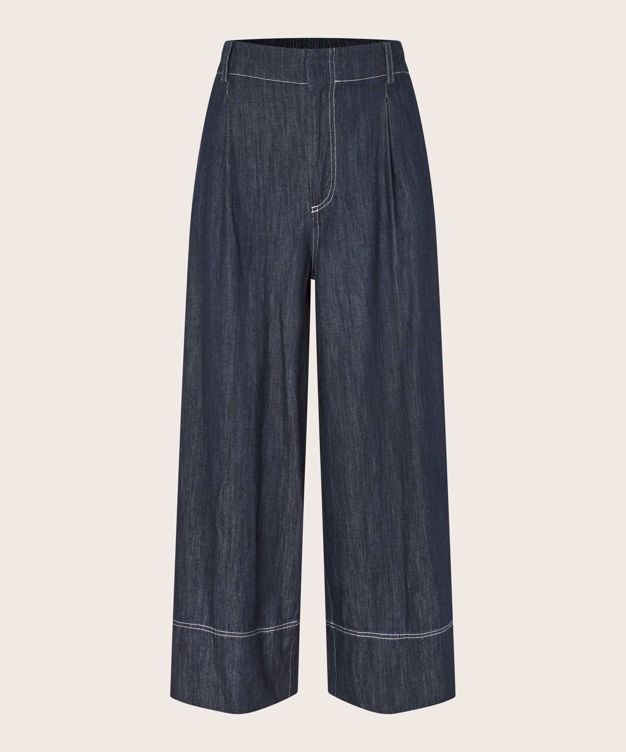 Pair of dark blue denim wide-leg pants on a light beige background