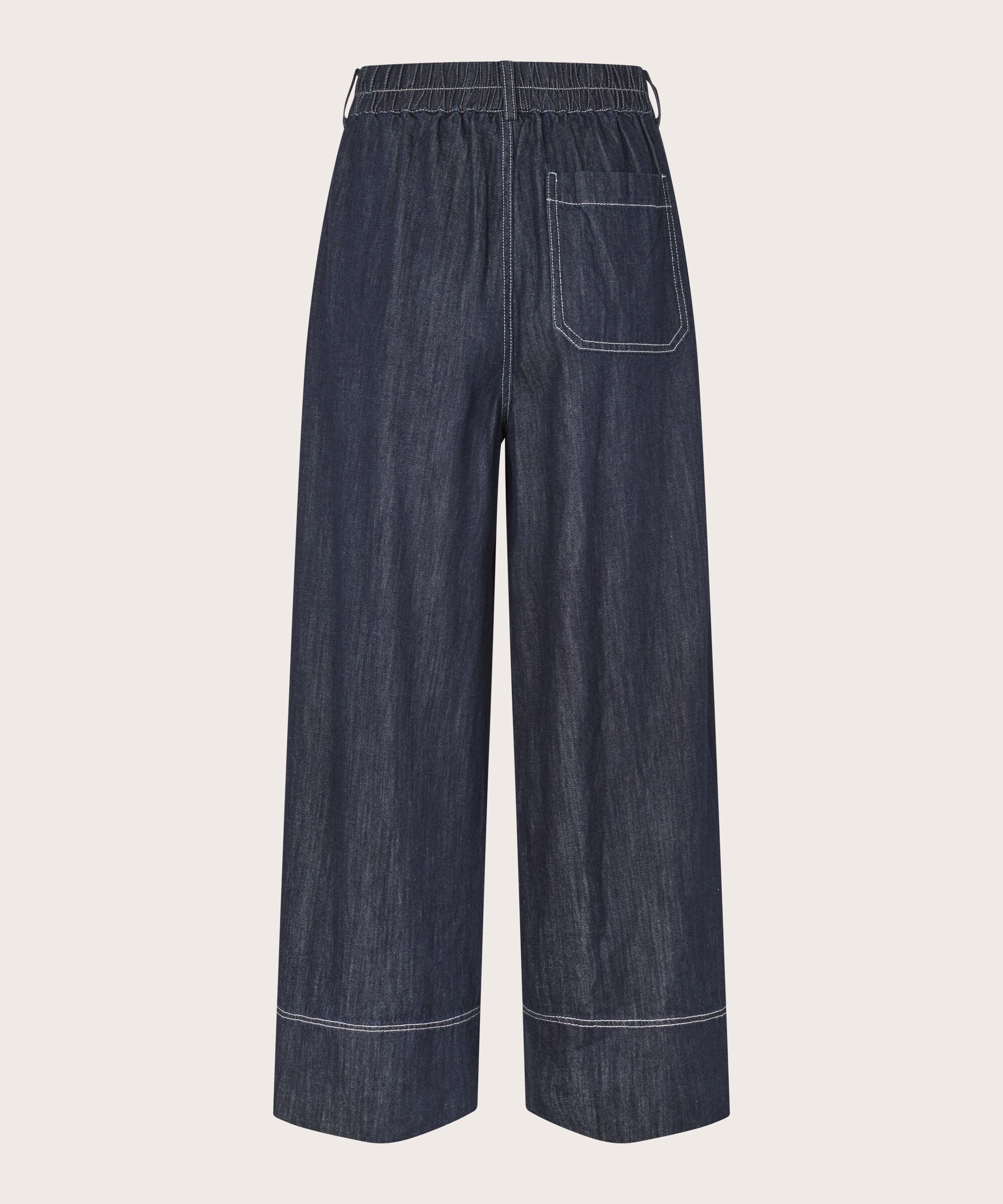 Dark blue denim pants on a light gray background