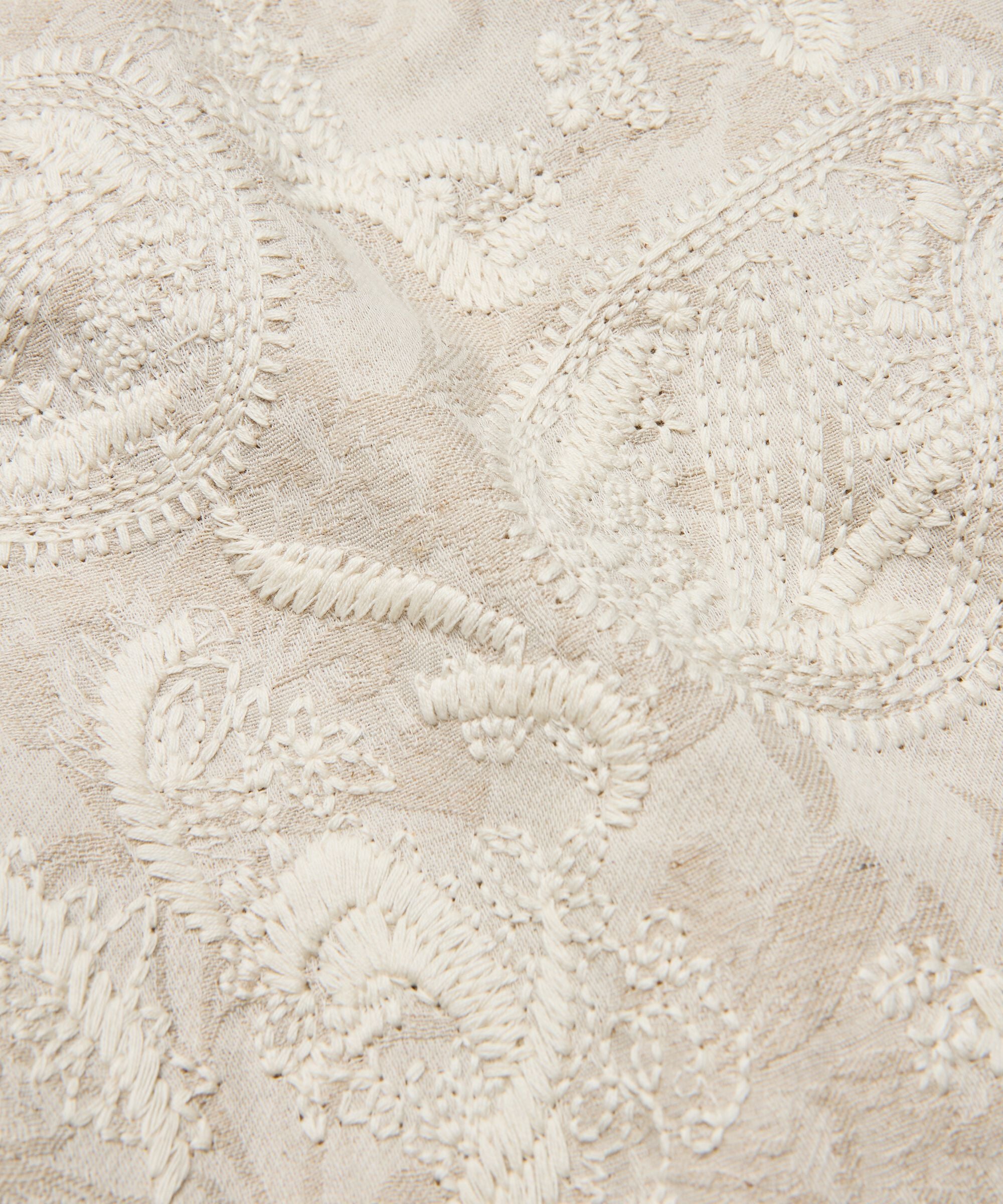 Close-up of textured beige fabric with intricate patterns