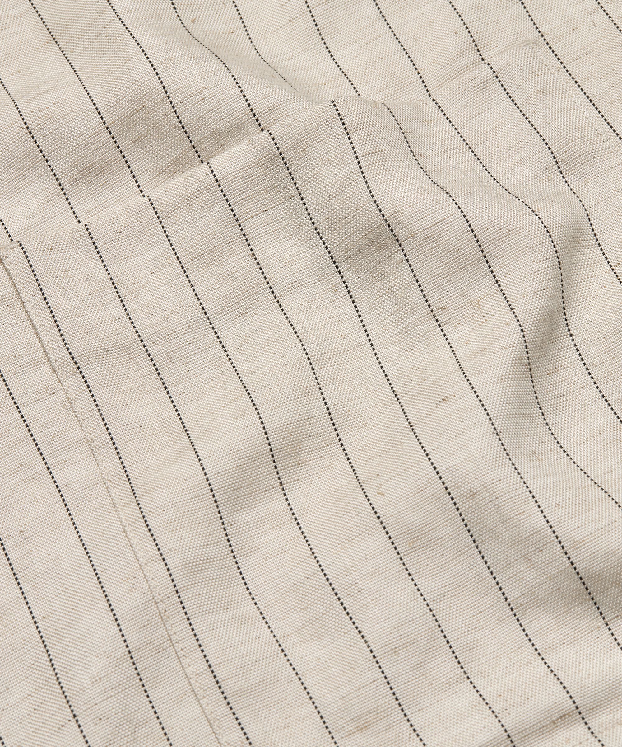 Close-up of beige fabric with vertical stitching