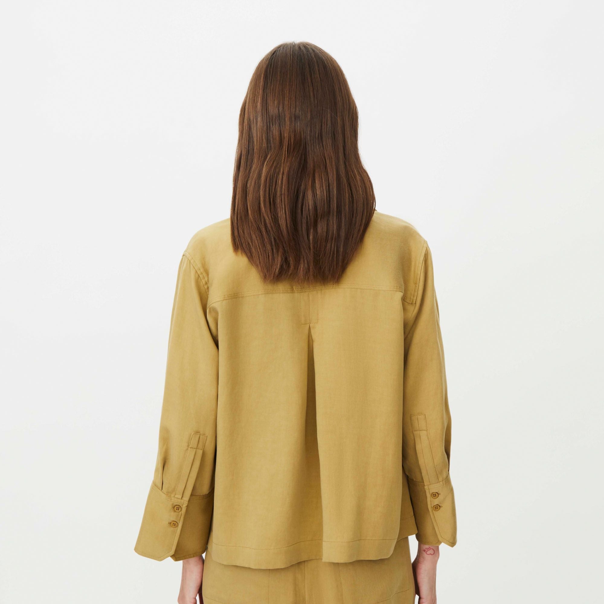 Person wearing a mustard yellow outfit on a white background
