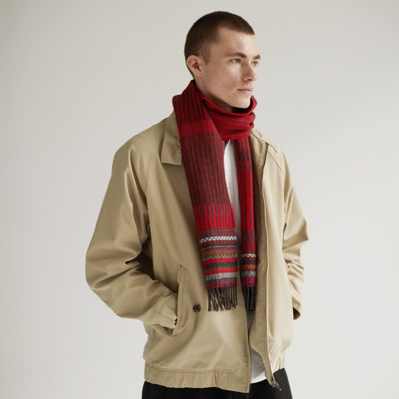 Red and brown striped wool scarf with multicolored woven detail and tassels.