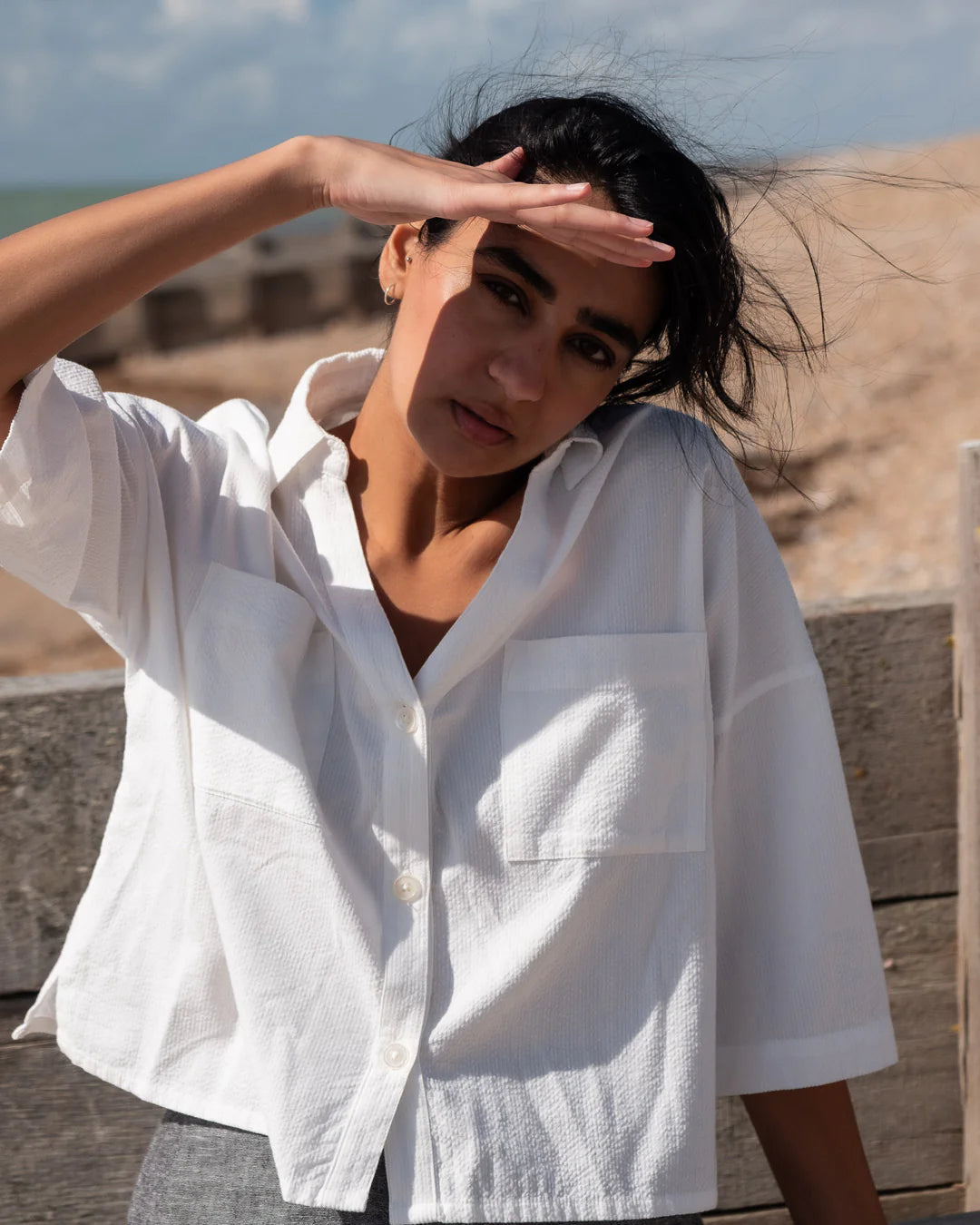 Woman wearing a white shirt outdoors with a neutral background