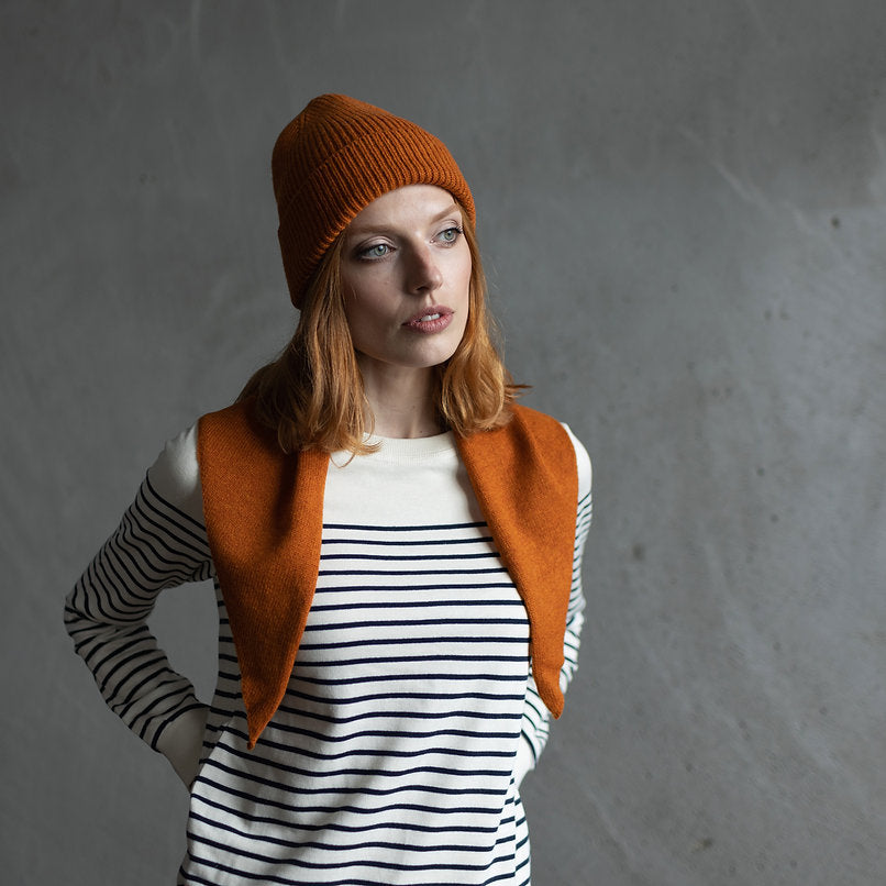 Burnt orange ribbed knit beanie and matching triangular scarf.