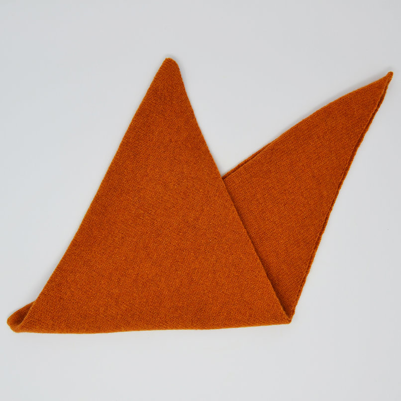 Burnt orange triangular knit scarf folded.