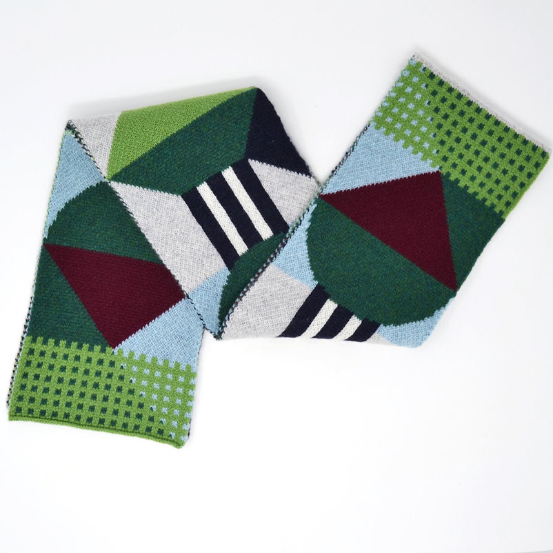 Geometric patterned knit scarf in greens, blues, and burgundy.