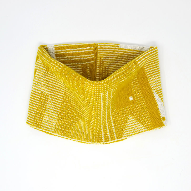 Mustard yellow knit neck warmer with white geometric pattern.
