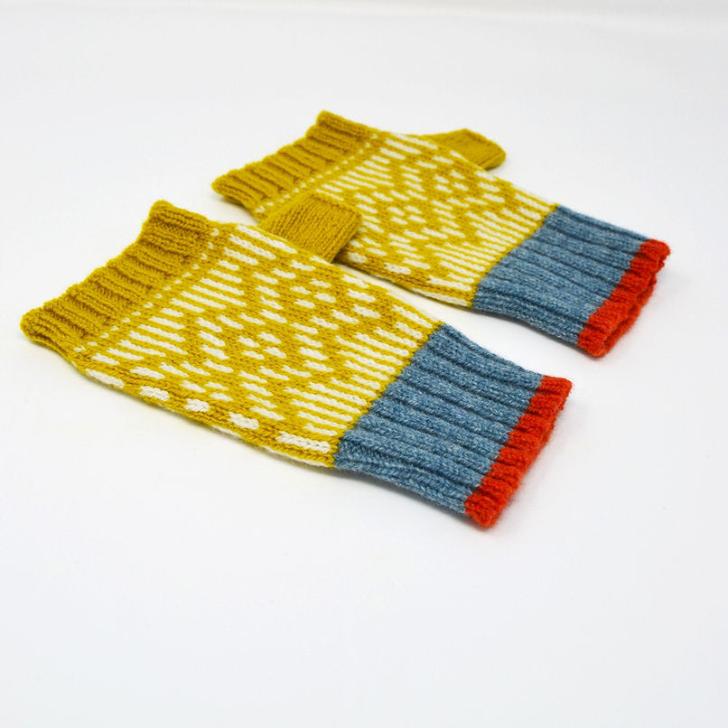 Pair of hand-knitted fingerless gloves. Mustard yellow and white patterned body with blue and orange cuffs.