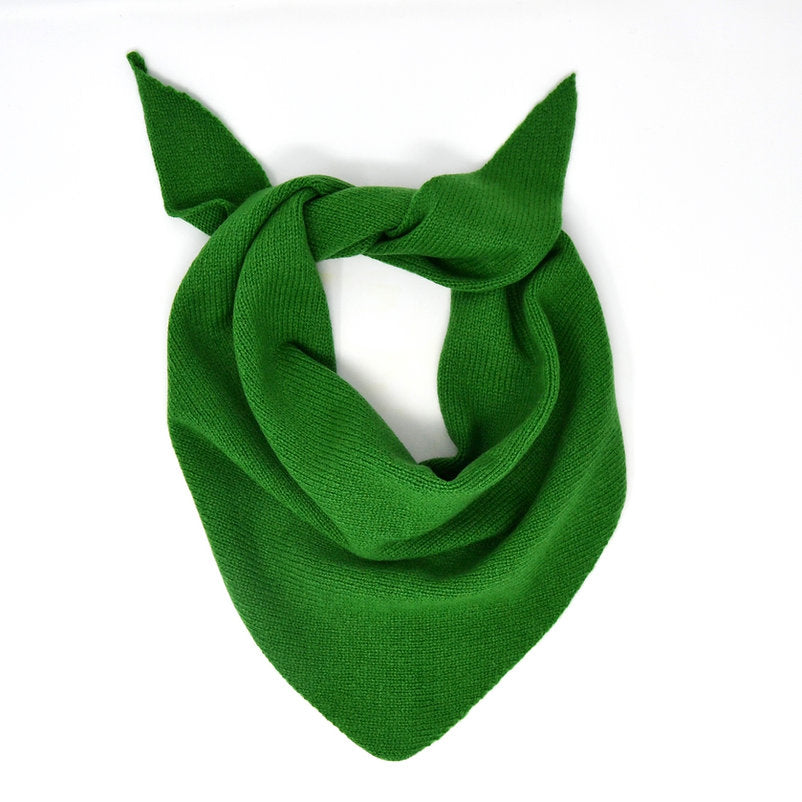 Bright green knitted triangular scarf, loosely knotted.