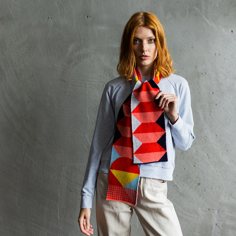 Geometric patterned scarf in red, pink, black, yellow, and light blue.