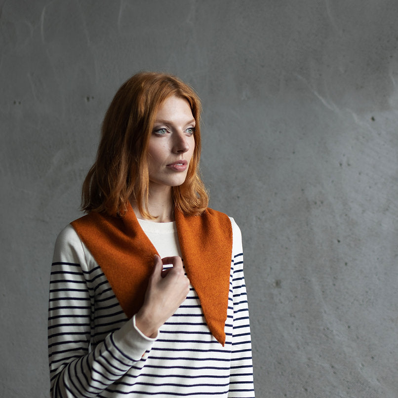 Burnt orange wool collar, V-shaped, worn over a white and navy striped long-sleeved shirt.