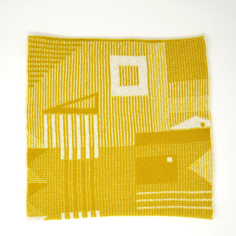 Mustard yellow knitted textile with an off-white geometric pattern.