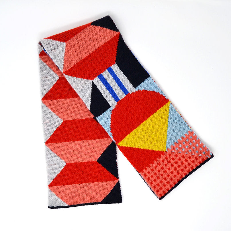 Geometric patterned knit scarf in red, pink, yellow, blue, and gray.