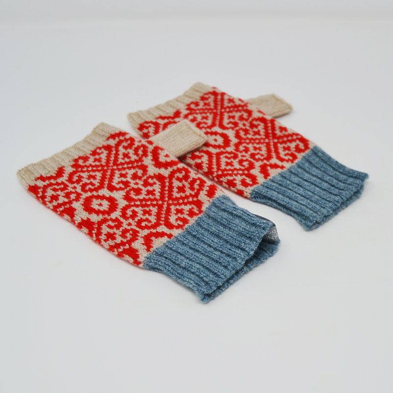 Pair of fingerless gloves with red and cream geometric pattern and blue cuffs.