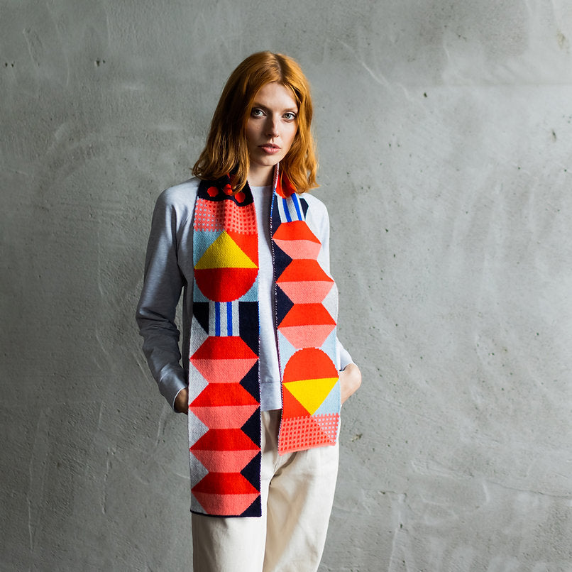 Geometric patterned scarf in red, pink, yellow, blue, and black.