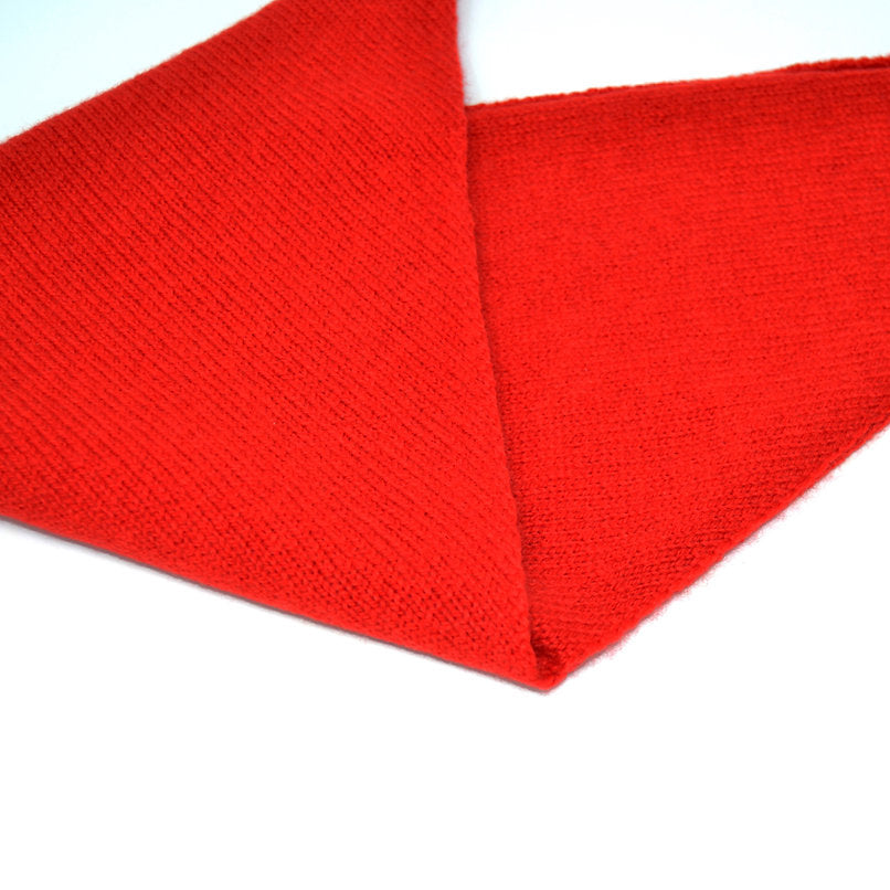 Bright red knitted scarf folded in a triangular shape.