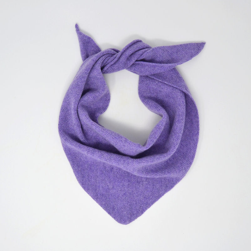 Purple knitted triangular scarf, loosely knotted.