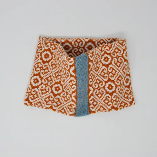 Orange and white geometric patterned knit neck warmer with a denim center stripe.