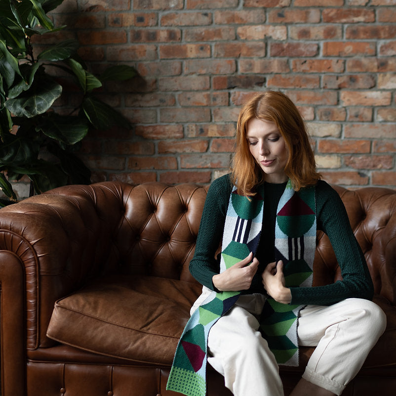 Geometric patterned scarf in greens, blues, and burgundy.  Long, rectangular shape.