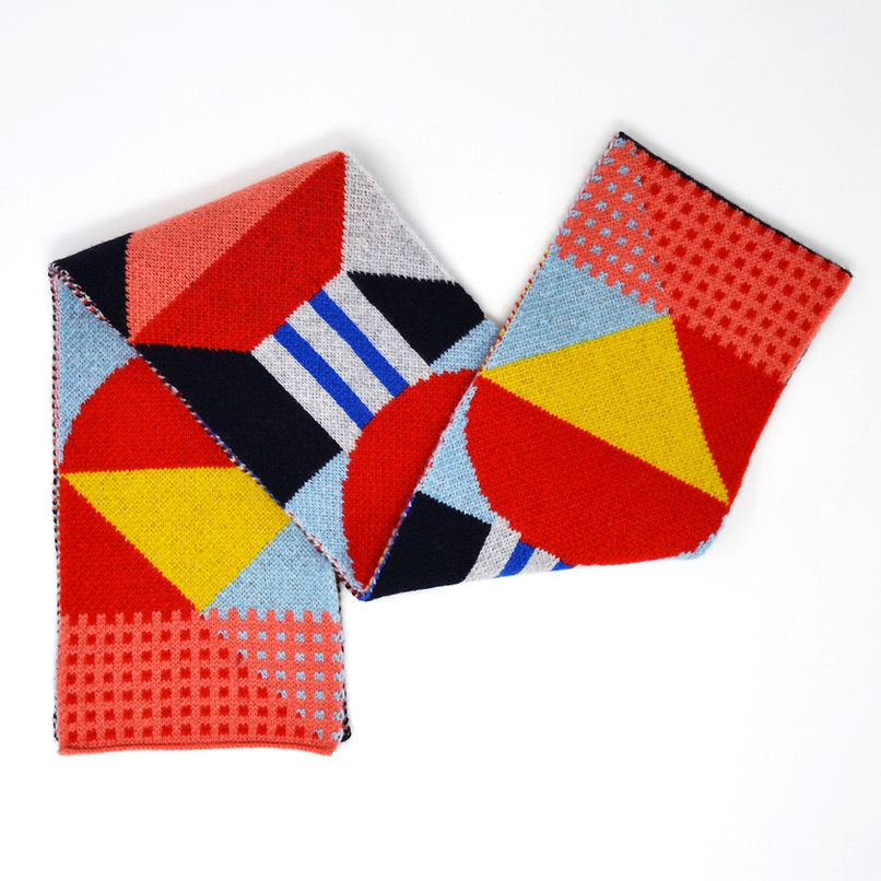 Geometric patterned knit scarf in red, yellow, blue, and pink.