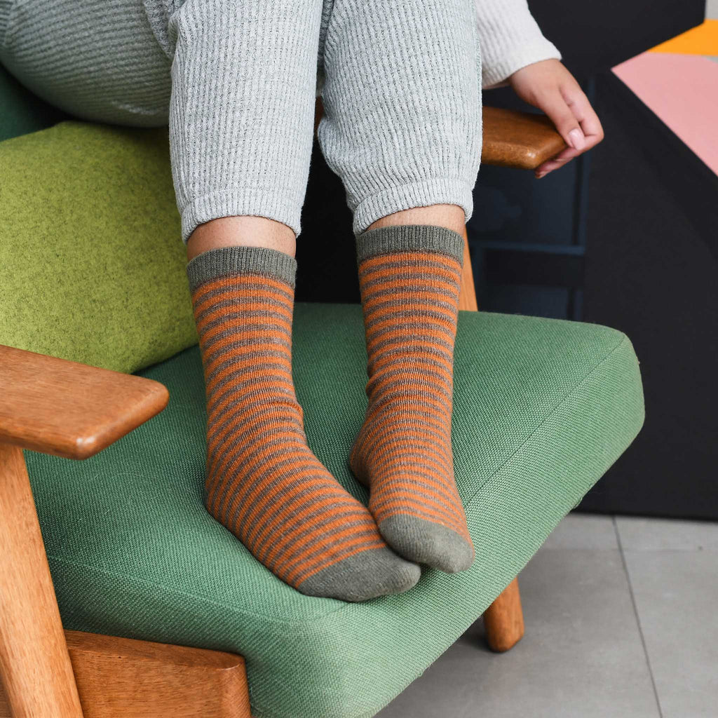 Pair of orange and olive green striped socks.