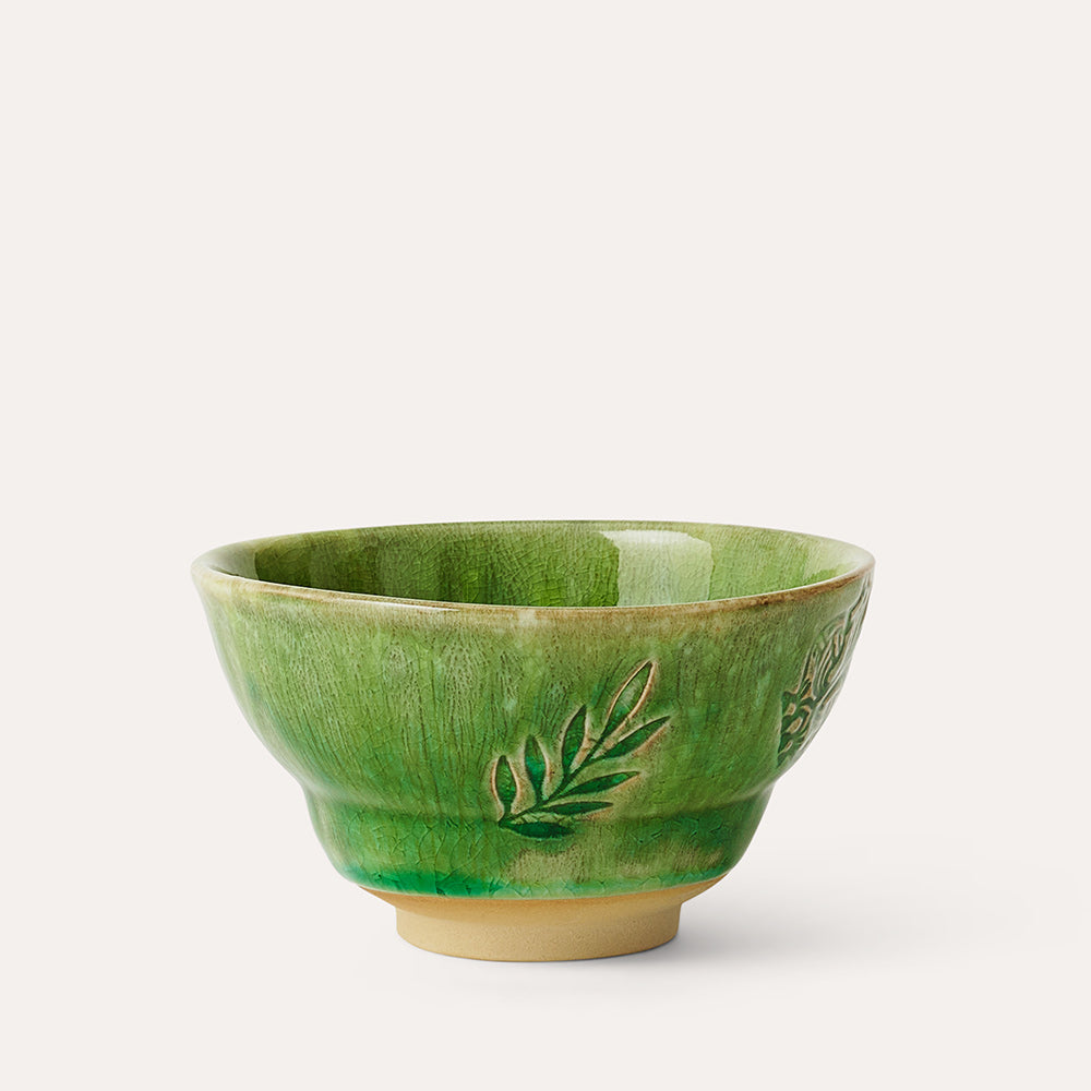 Green ceramic bowl with embossed leaf designs.  Slight variations in glaze create a textured appearance.
