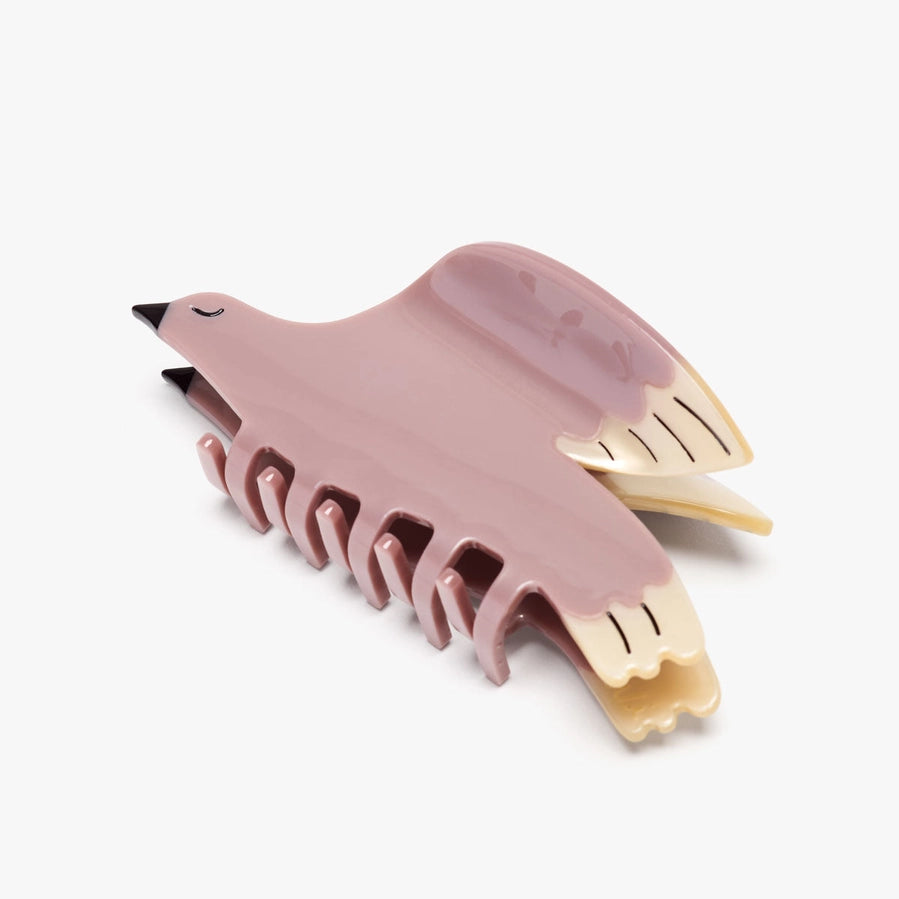 Pink bird-shaped hair clip on a white background