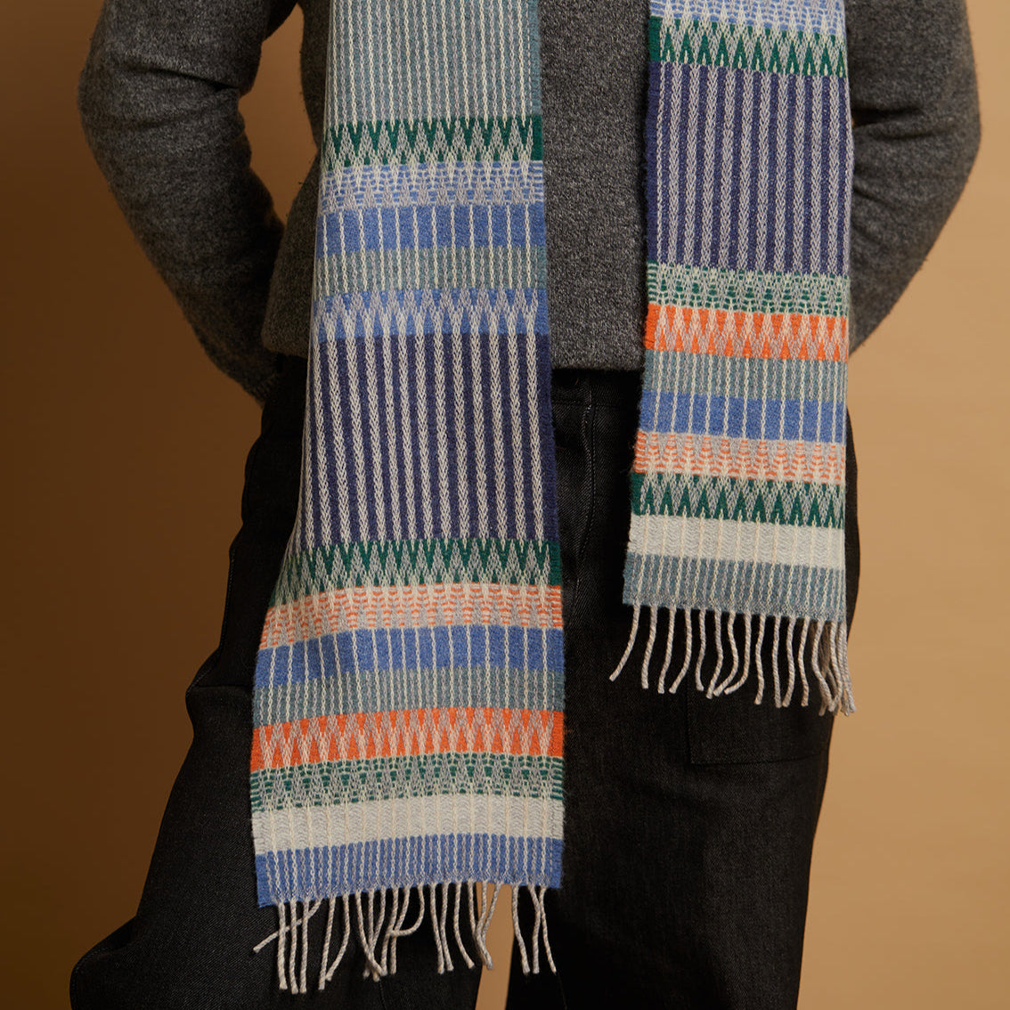 Person wearing a patterned scarf with a brown background