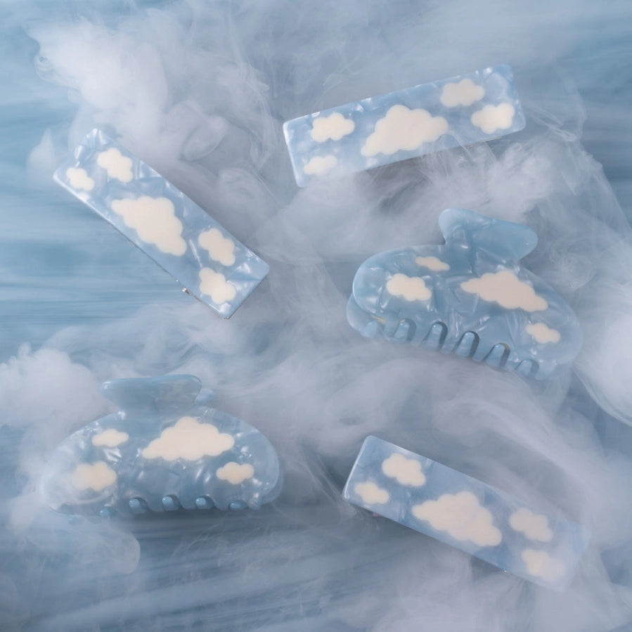 Clear hair clips with cloud designs on a smoky blue background