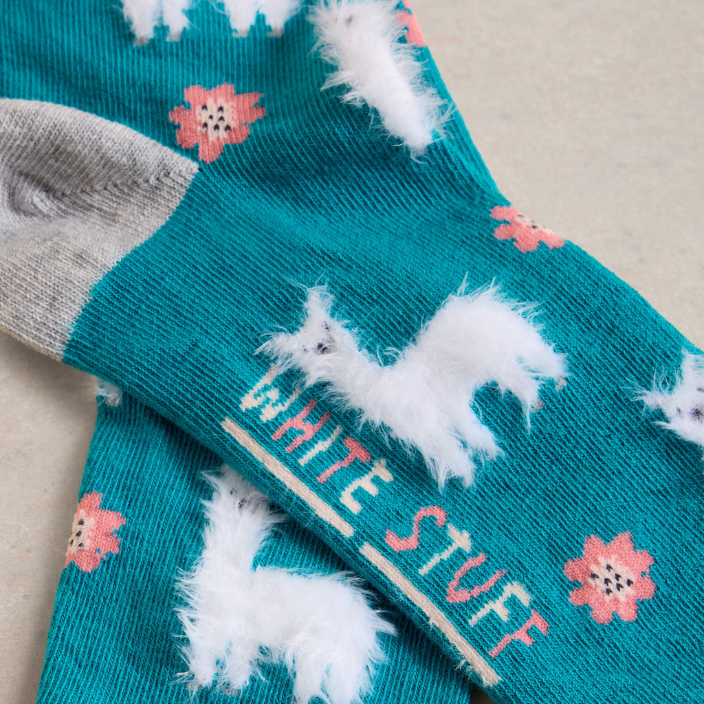 Teal socks with white fluffy llama designs and "White Stuff" text.