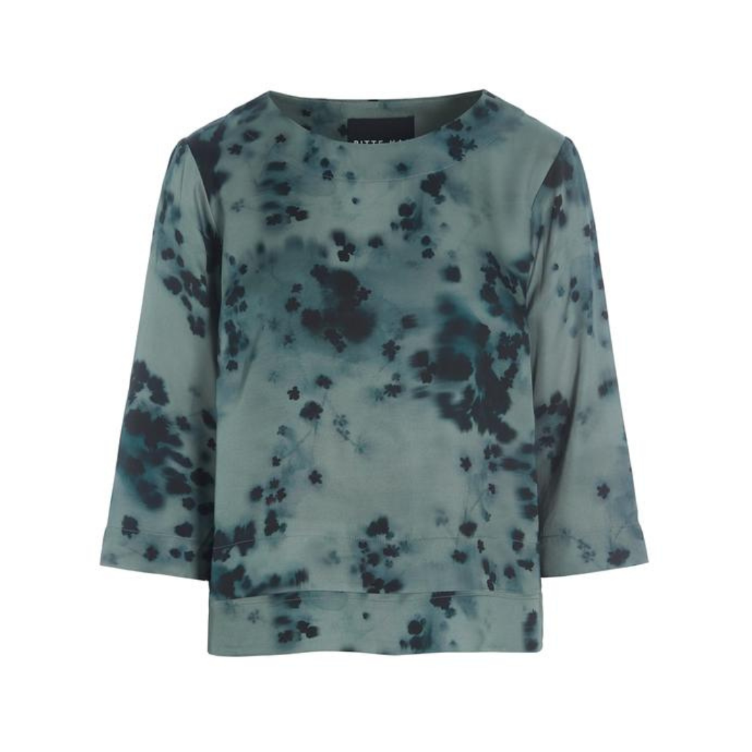 Long-sleeve top with blue and black abstract pattern on a white background