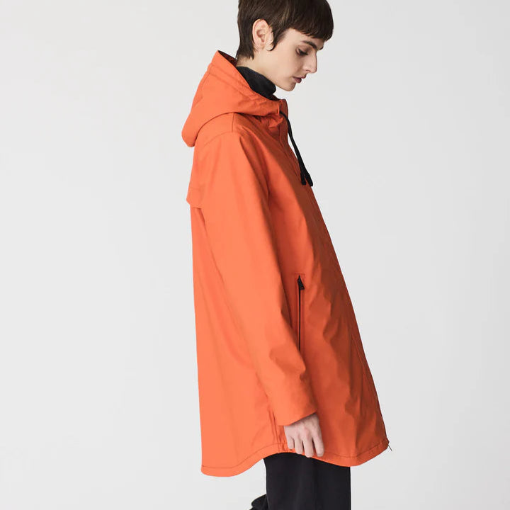 Person wearing an orange raincoat on a white background