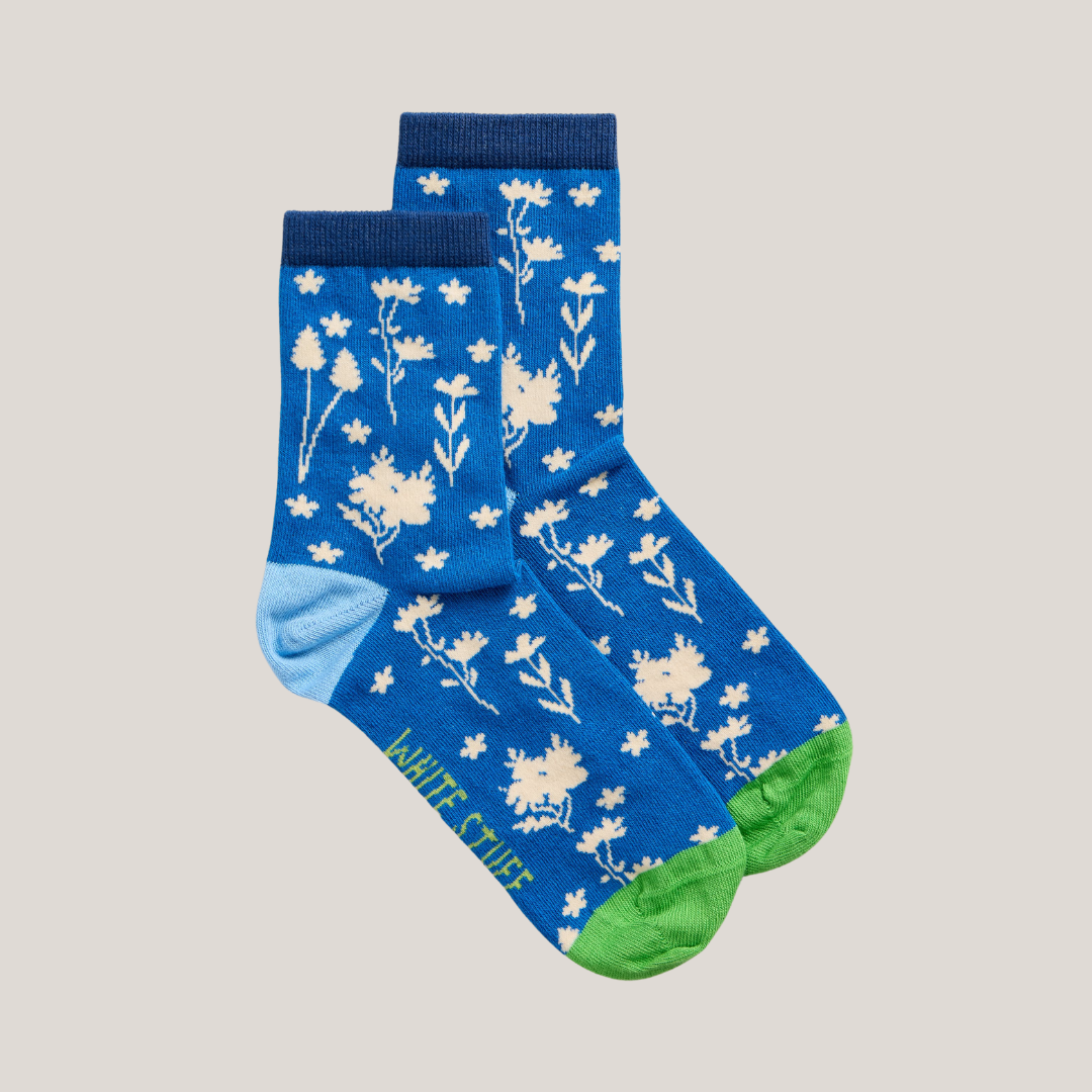 Pair of blue ankle socks with a white floral pattern and lime green heel and toe.