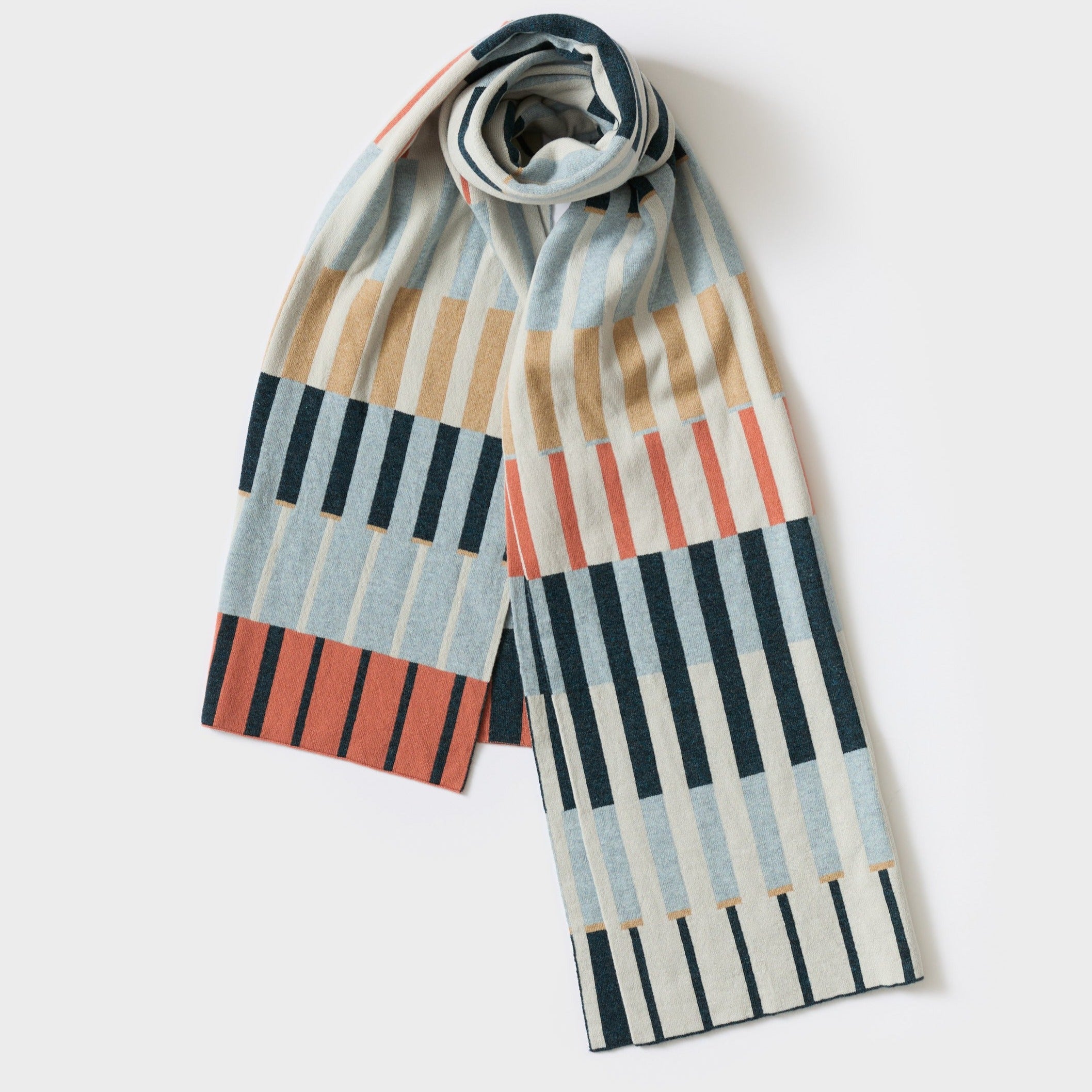 Knit scarf with a geometric pattern in shades of blue, coral, beige, and dark teal.