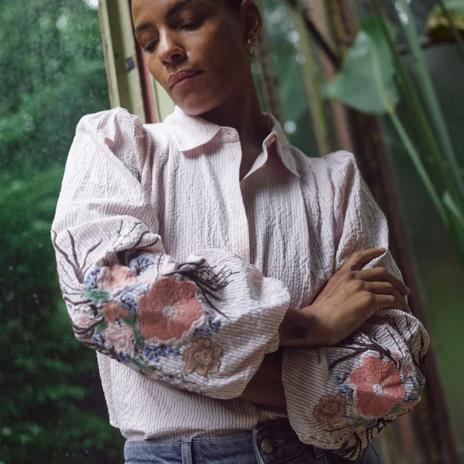 Woman wearing a floral blouse with a blurred green background