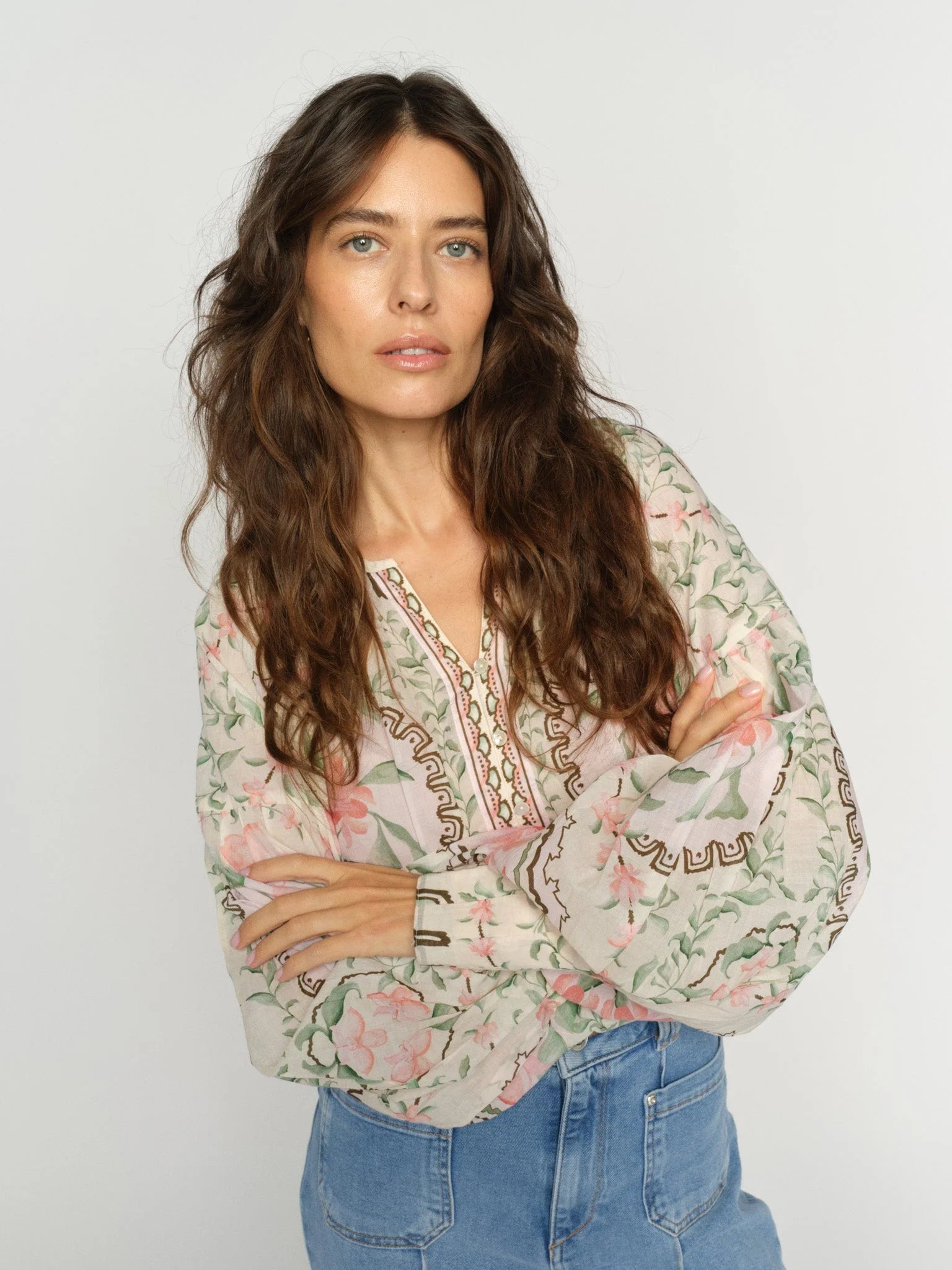 Woman wearing a floral blouse with a plain background