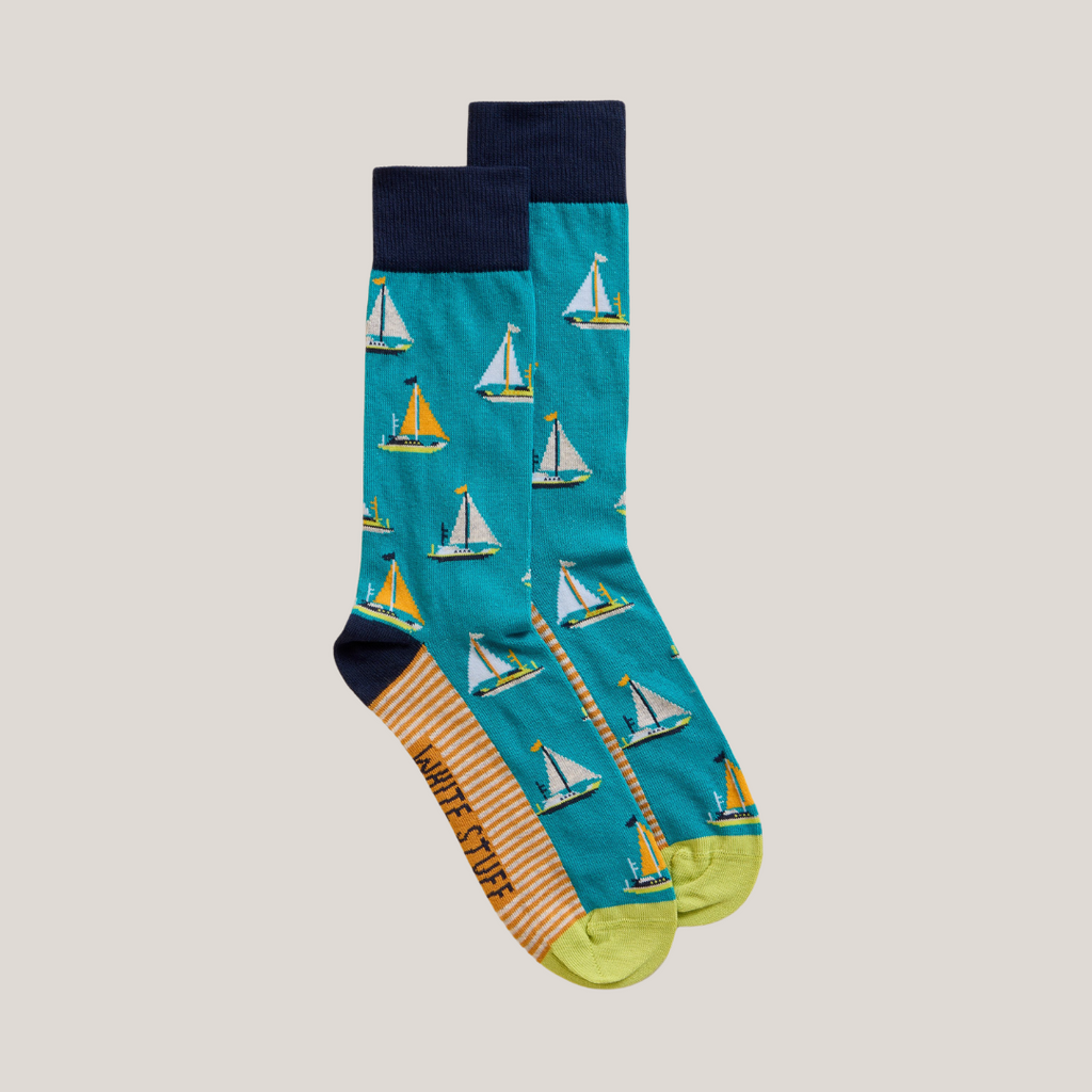 Pair of teal socks with a repeating pattern of small sailboats.