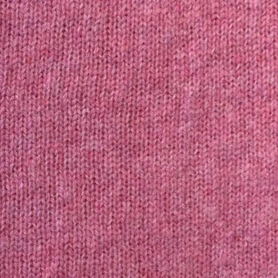 Close-up of a mauve-pink knitted fabric with a fine, slightly textured weave.