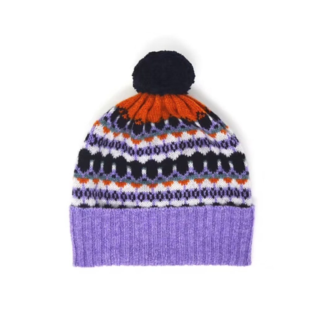 Purple knit beanie with a black pompom and a colorful Fair Isle pattern.
