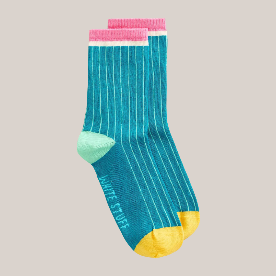 Pair of teal socks with pink and yellow accents on a beige background