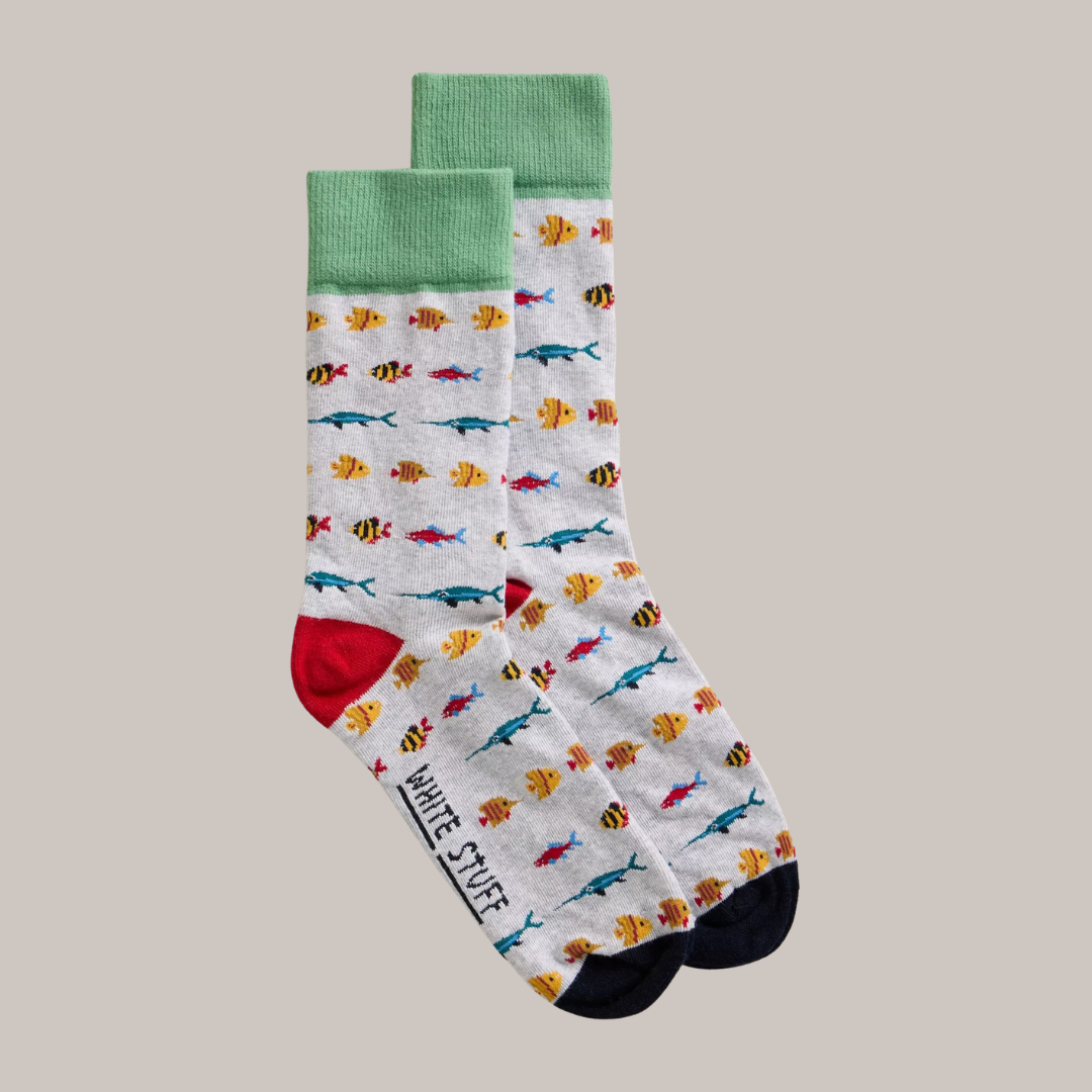 Pair of grey socks with a colorful fish pattern, green cuffs, and red and navy heels.