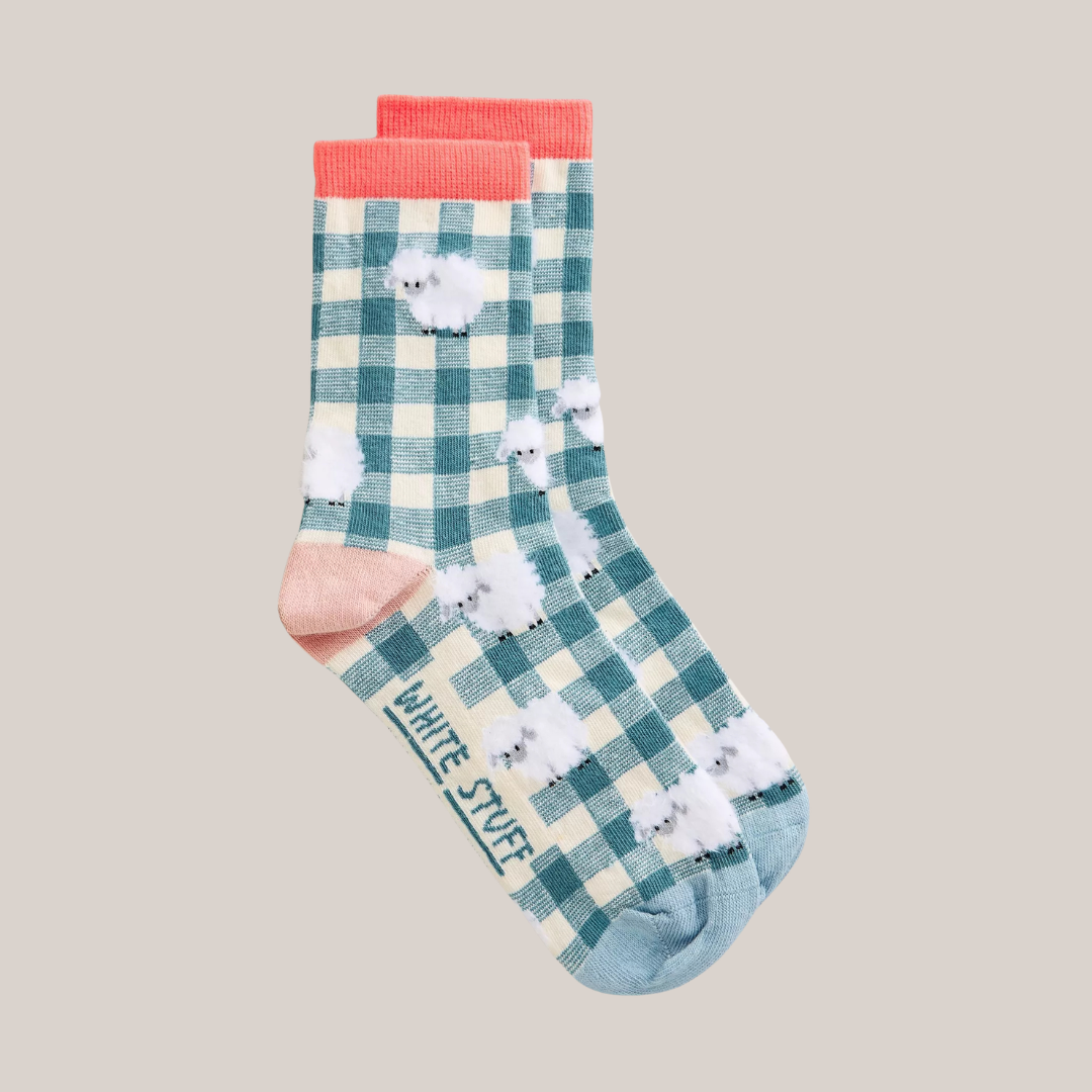 Plaid socks with sheep design and red accents on a beige background