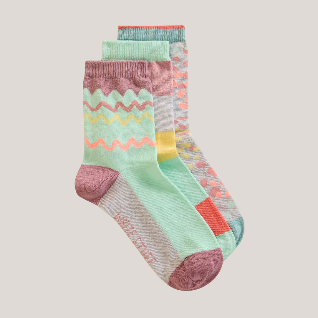 Three pairs of pastel-colored ankle socks with geometric and wavy patterns.