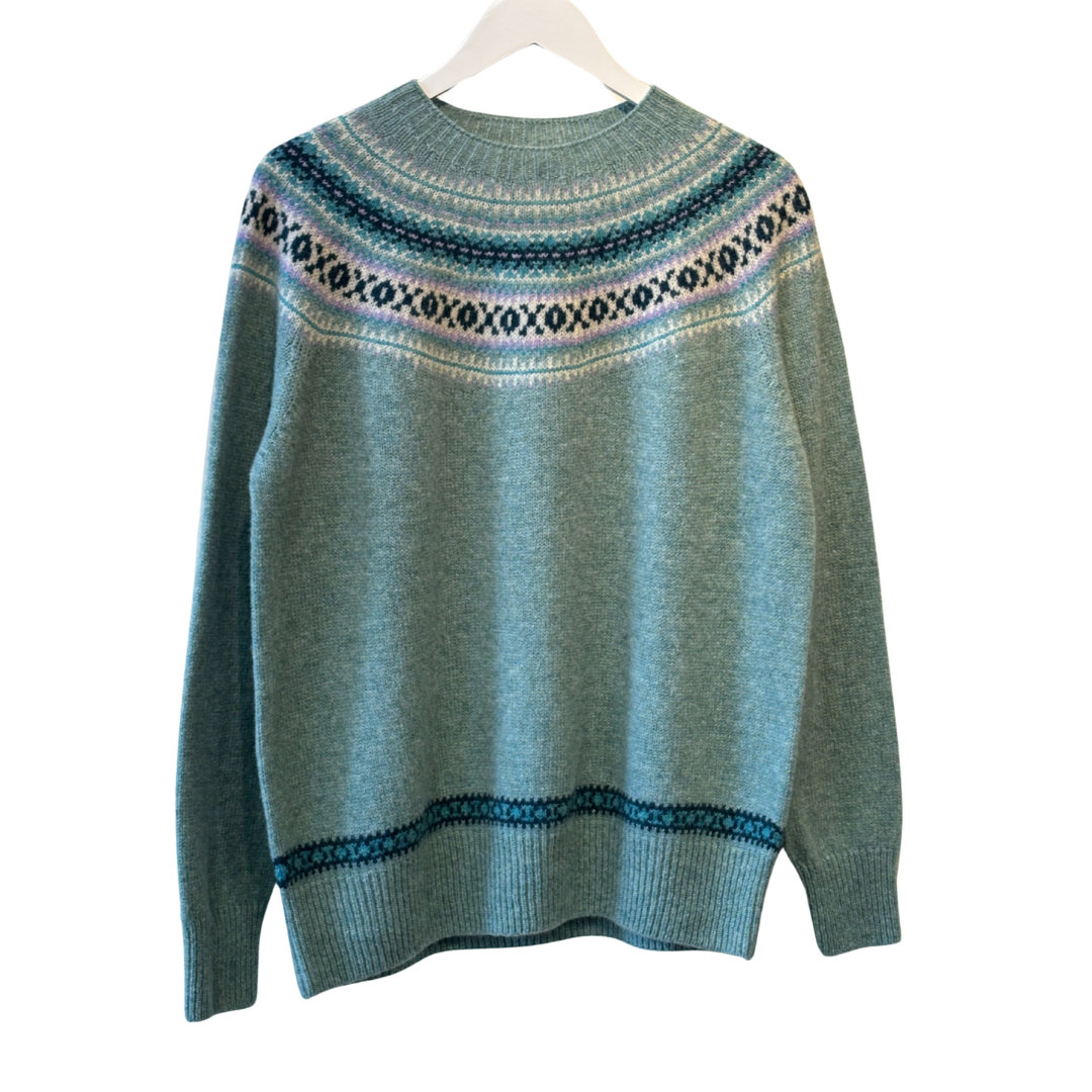 Teal crewneck sweater with a Fair Isle-style yoke and hem detailing in shades of teal, purple, and white.