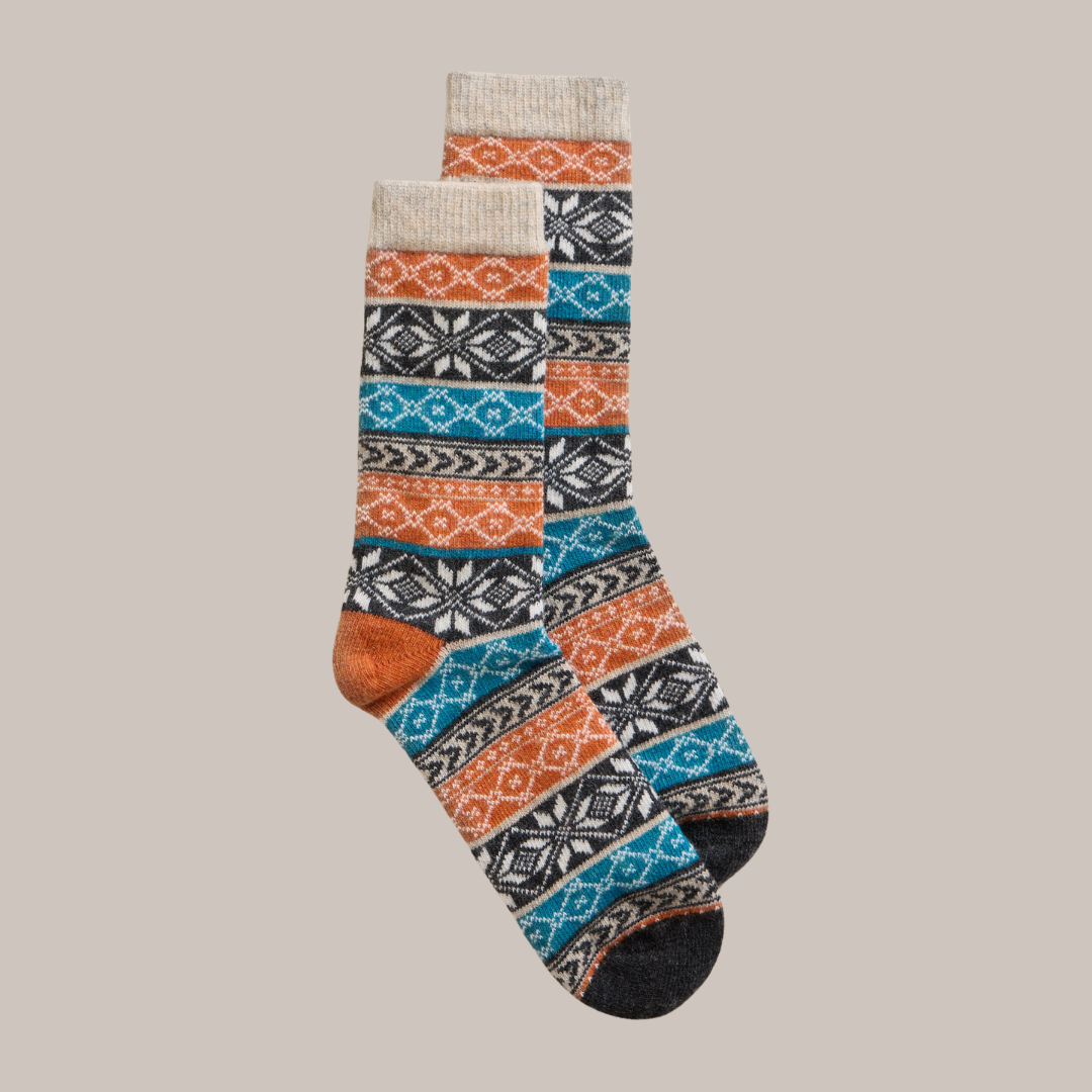Pair of wool socks with orange, teal, and gray Fair Isle pattern.