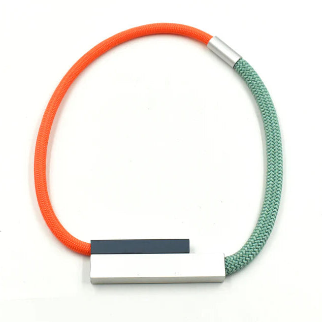 Modern necklace with orange and teal rope and a silver and dark gray rectangular pendant.